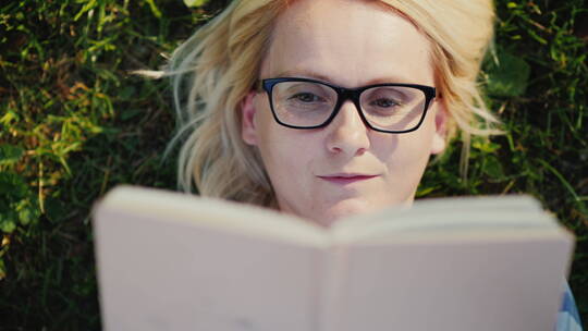 躺在公园草坪看书的女人