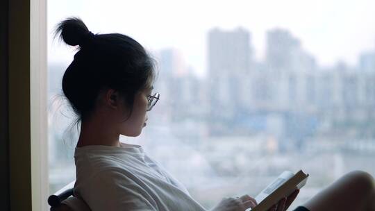女孩在落地窗前看书4k视频素材视频素材模板下载
