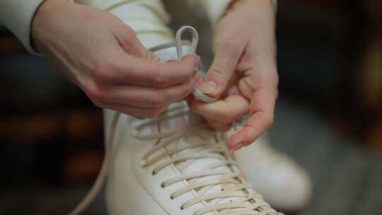 准备溜冰鞋溜冰场特写手系上白色溜冰鞋