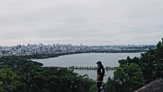 小轮车手在宝石山上俯瞰杭州城市