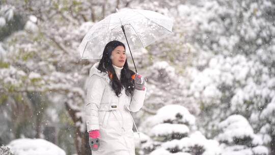 大雪纷飞打伞的女孩美女走路