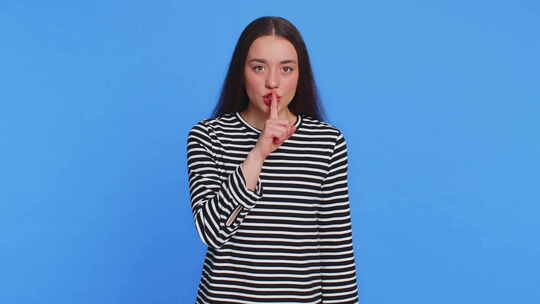 年轻女子用手指按住嘴唇做出沉默手势不要告视频素材模板下载