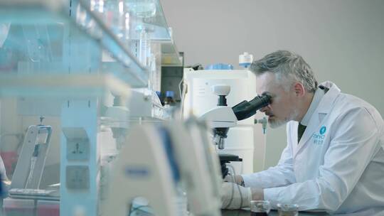 白胡子外籍专家实验室内操作显微镜视频素材模板下载