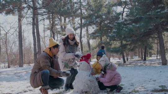 快乐家庭在雪地里堆雪人