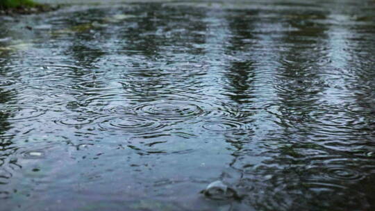 雨落到街道排水沟的画面