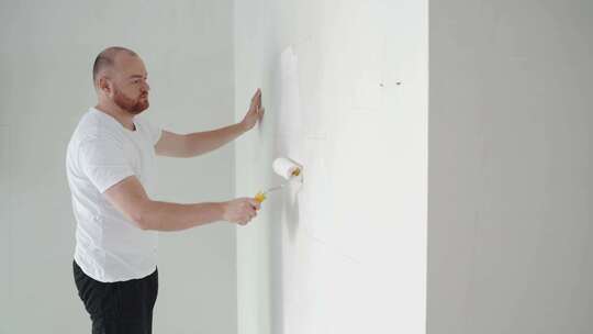 画家用滚筒粉刷墙壁视频素材模板下载