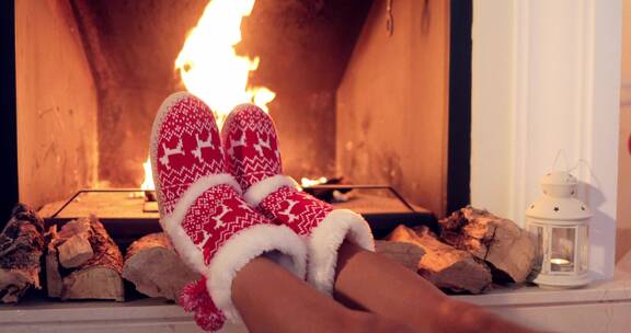 女子在圣诞节穿着短靴在烤火