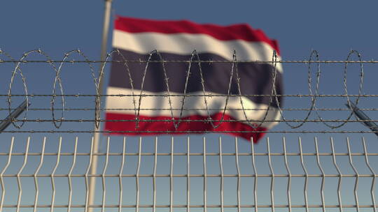 铁丝网后面模糊的泰国国旗
