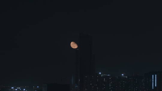 月亮划过城市建筑月亮升起