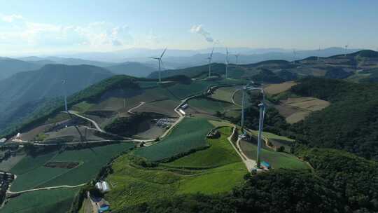 一个高处宁静的乡村，风力涡轮机静静地运转着。