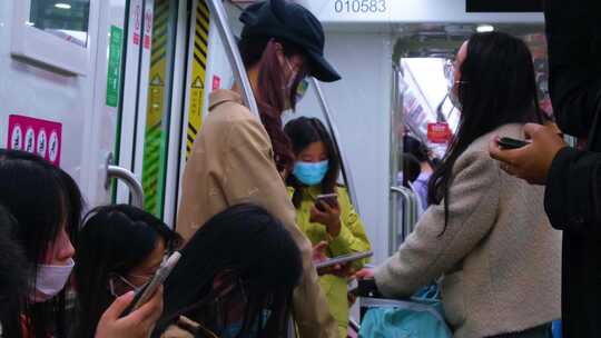 城市乘坐地铁玩手机的年轻人