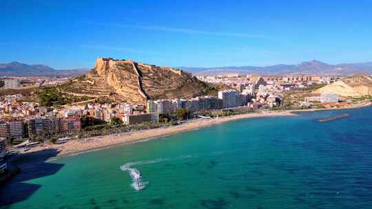 西班牙阿利坎特的Playa de postiguet，背景是圣巴巴拉城堡。酒店和