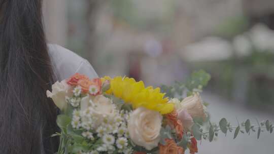 云南昆明怀抱鲜花的女孩走在街道上