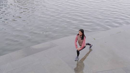 一个女人在河边做伸展运动视频素材模板下载