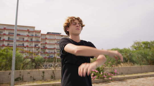 穿着黑色衬衫的小男孩在篮子场的户外呼吸空