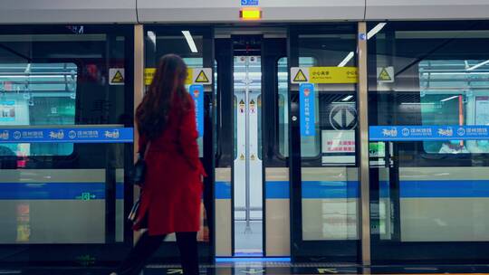 乘坐地铁上下车停靠站红衣女子春运春节元旦