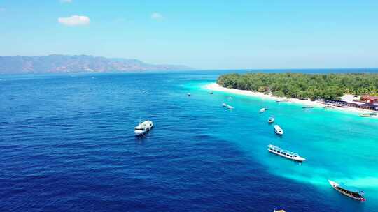 停泊在蓝色蓝色泻湖上的旅游船，靠近位于热带岛屿海岸的度假胜地，白色