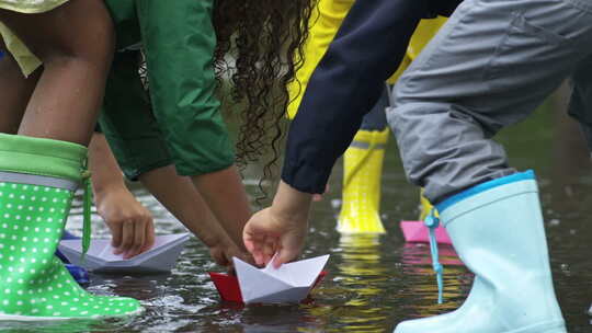 孩子们把纸船放在水坑里