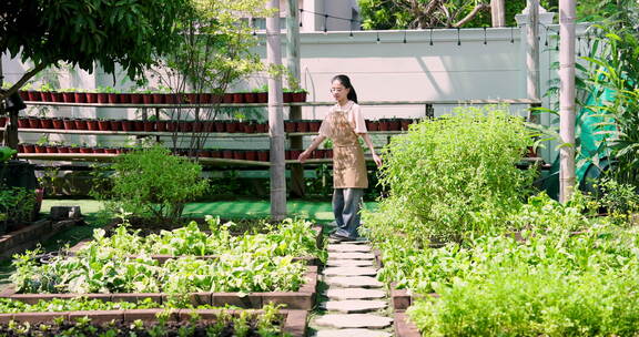 亚洲女人走过一个长满绿色植物的郁郁葱葱的