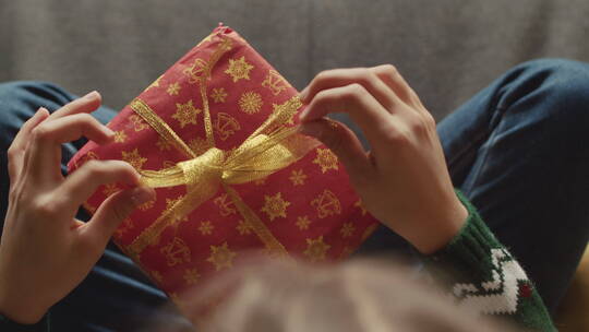 坐在沙发上玩圣诞礼盒的孩子