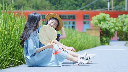 坐在绿色稻田里边的美少女闺蜜聊天玩耍乡村