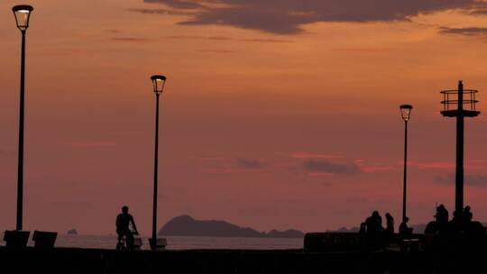 夕阳下海滩码头上的行人