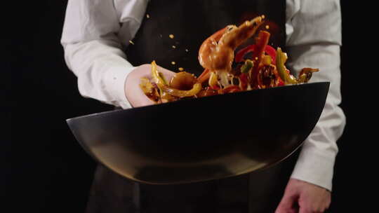 厨师在锅上用油烹饪火焰虾煎锅特写大虾在火
