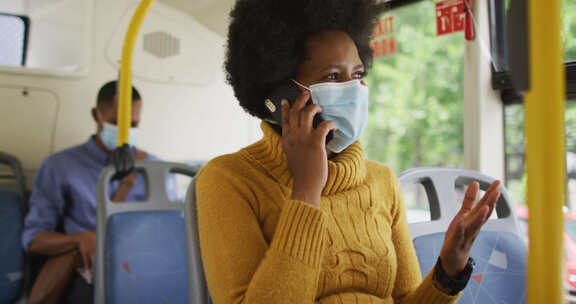 戴口罩的黑人女性在公交车上打手机