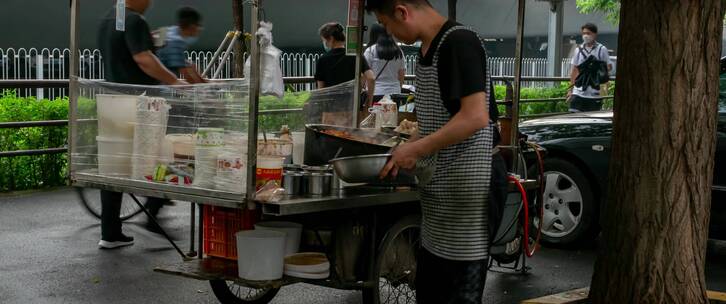 雨后傍晚城市街边高架桥下小吃摊