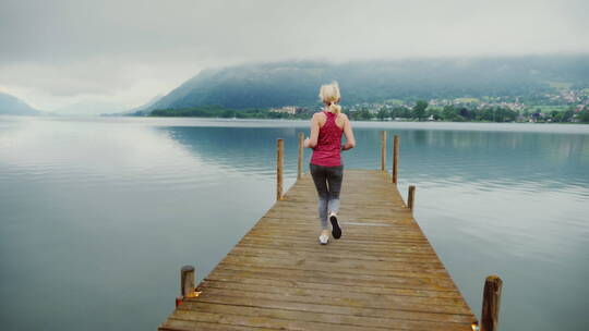 女人在奥地利阿尔卑斯山风景如画的山湖附近晨跑