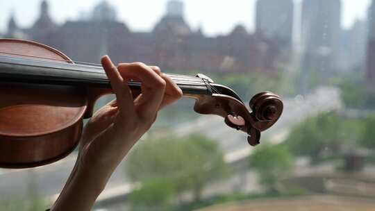 小提琴家窗前演奏唯美镜头