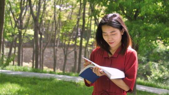 中国女性美女在公园树林看书学习