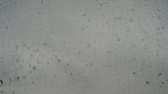 雨滴滴落在窗户上雨天窗户车窗下雨天雨水