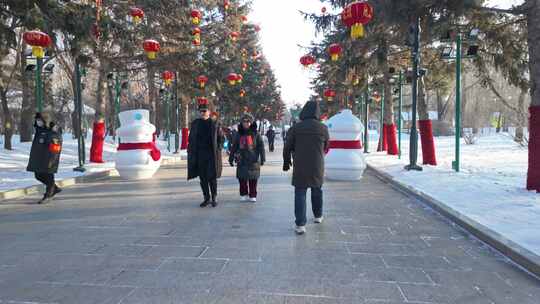 挂满红灯笼的雪天公园道路节日氛围雪人春节