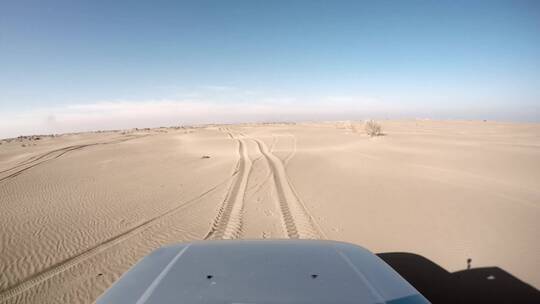 一辆汽车在沙漠中行驶的前视图