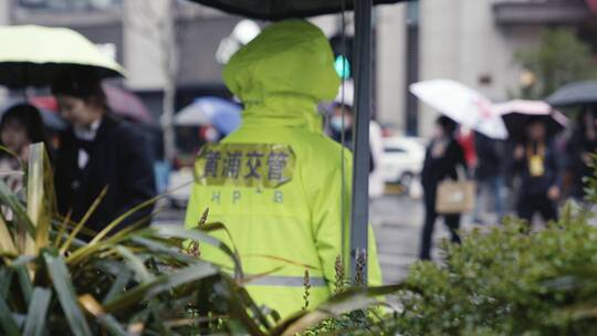 南京路下雨行人撑伞过马路交警站岗红绿灯视频素材模板下载