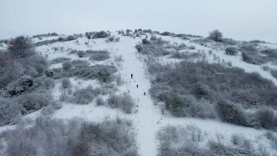 一座白雪覆盖的小山，人们在上面行走