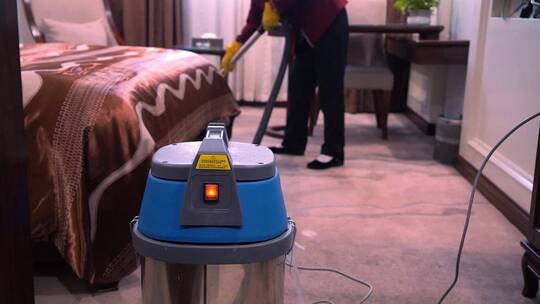 实拍酒店保洁阿姨用吸尘器打扫房间地面卫生