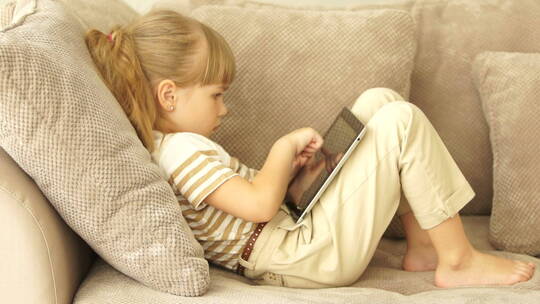 小女孩用平板电脑玩游戏