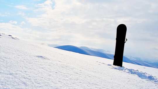 雪山背景的黑色单板滑雪
