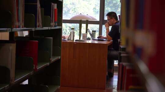 一名男子在图书馆看书用心