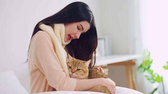 亚洲年轻女子在家里的卧室里快乐地和小猫玩