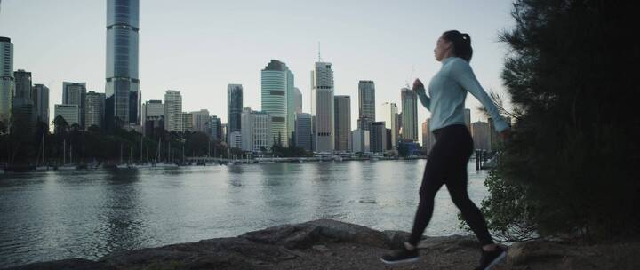 穿着运动服的女人在河边跑步