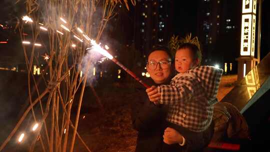 成年人抱小孩夜晚手持烟花