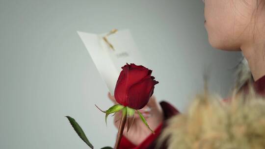 4K情人节美女拿着玫瑰花阅读卡片升格视频
