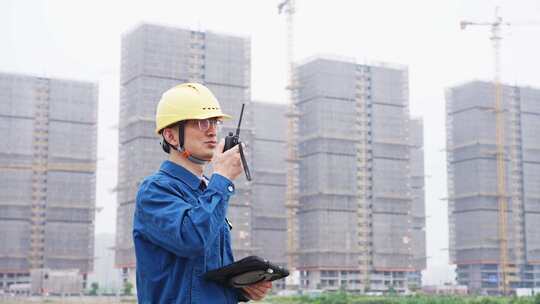 工程师拿着对讲机在工地指挥工作