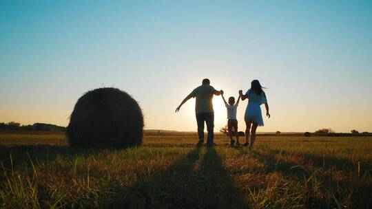 一家人在傍晚的田野上游玩