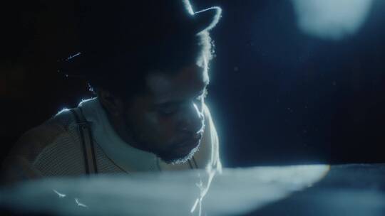 在光影中独自弹奏钢琴的男人