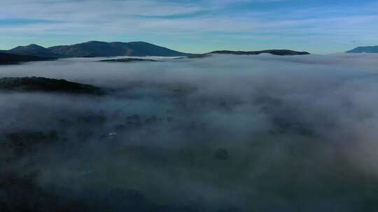 黎明时分，无人驾驶飞机飞越山谷中的云海，