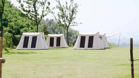 阳光下草地上露营的帐篷航拍